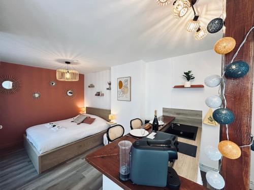 une chambre d'hôtel avec un lit et un bureau avec un bureau dans l'établissement Chez Cath Studio neuf cosy proche centre-ville, à Reims