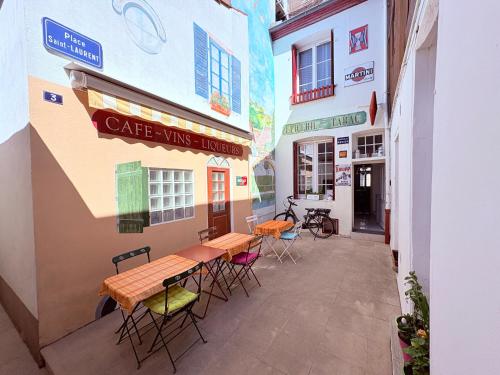 Verdun-sur-le-DoubsにあるDoubs Séjour - Chambres climatisées Petits déj en supplémentの建物の中にテーブルと椅子が置かれたパティオ