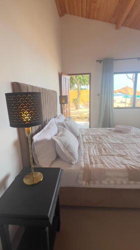 a bedroom with a bed and a lamp on a table at Villa ArthurCC in Hikkaduwa