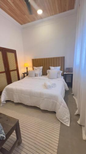 a bedroom with a large bed with white sheets and pillows at Villa ArthurCC in Hikkaduwa