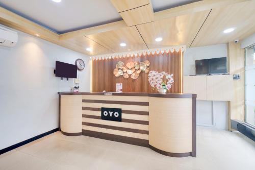 an office lobby with a reception desk with a clock at Dancenter Tanjung Duren Near Mall Citraland Formerly Suba Hotel in Jakarta