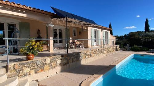 une maison avec une piscine devant une maison dans l'établissement Villa du pointu 3 ch, quiet and air-conditioned, au Thoronet