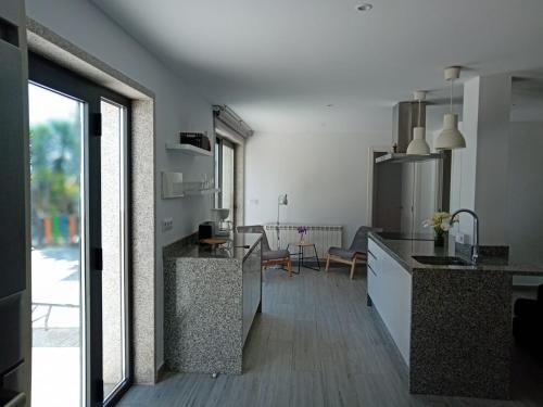 una cucina con bancone e una sala da pranzo di Espectacular casa moderna con jardín y terraza a Parderrubias