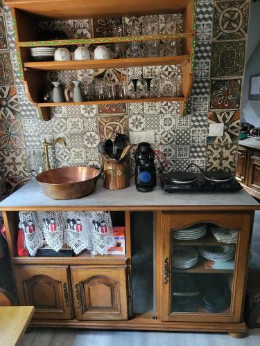 une armoire en bois avec des assiettes et de la vaisselle dans l'établissement Quiet apartment in historic village, à Oberbronn