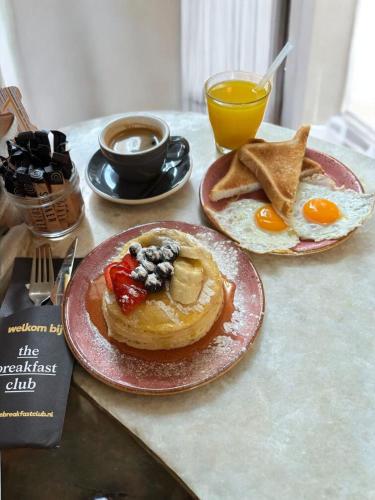 two plates of breakfast food on a table with eggs and toast at Hotel National Antwerp in Antwerp