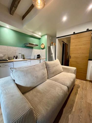 un salon avec un canapé dans une cuisine dans l'établissement La Cour Chartraine - Cosy appartement avec cour extérieur à Blois, à Blois