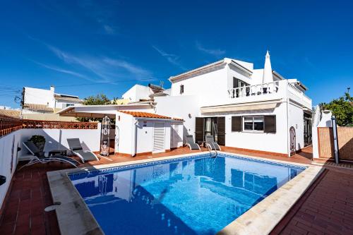 a swimming pool in front of a white house at Villa Leonie in Lagos