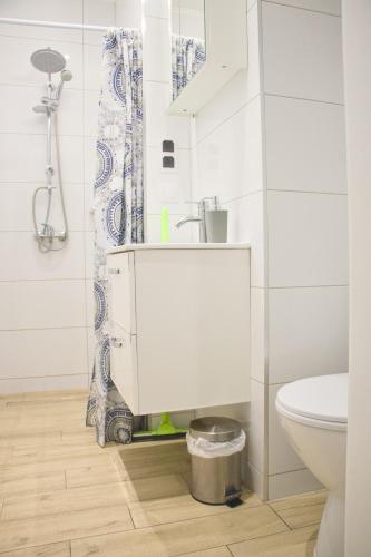 a white bathroom with a sink and a toilet at Studio z widokiem na rzekę in Przemyśl