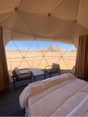 1 dormitorio con cama y vistas al desierto en Al-Faris Camp, en Disah