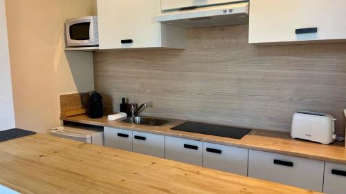 a kitchen with a sink and a counter top at Les tomettes du faubourg in Nevers