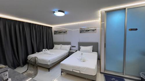 a hospital room with two beds and a window at Golden Mango home hotel 金芒果之家酒店 in Bangkok