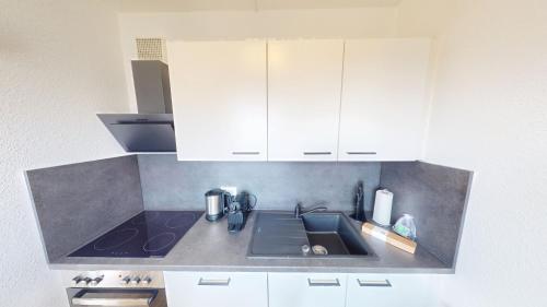 a kitchen with a sink and white cabinets at Hier ist Platz für vier, nur 200m bis zur Haltestelle der Linie 5, WLAN in Chemnitz