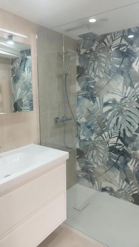 La salle de bains est pourvue d'une douche et d'un lavabo blanc. dans l'établissement Charmant appartement au coeur du village, à Tourrettes-sur-Loup