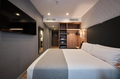a bedroom with a large white bed in a room at Catalonia La Maquinista in Barcelona