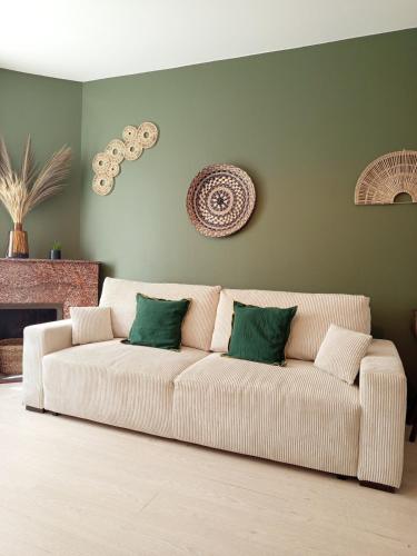 - un salon avec un canapé blanc et 2 oreillers verts dans l'établissement Kalipay - 7 min à pied des Grands Buffets, à Narbonne