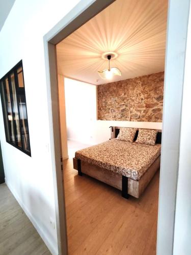 une chambre avec un lit et un mur de briques dans l'établissement Kalipay - 7 min à pied des Grands Buffets, à Narbonne