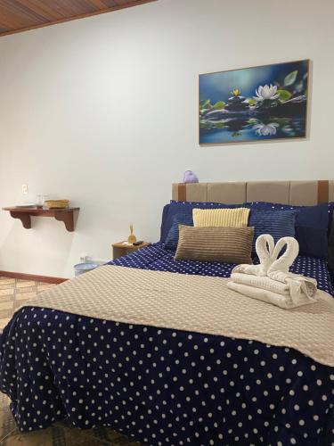 a bed with blue and white polka dot sheets and towels at Suítes Aconchego dos Pinhais in Santo Antônio do Pinhal