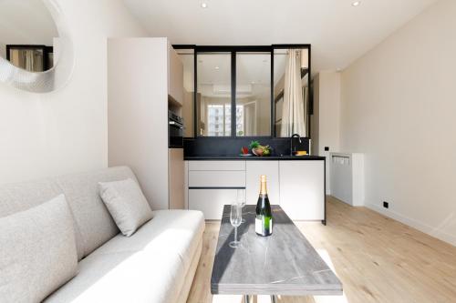 un salon avec un canapé blanc et une table en verre dans l'établissement Palais Miramar YourHostHelper, à Cannes