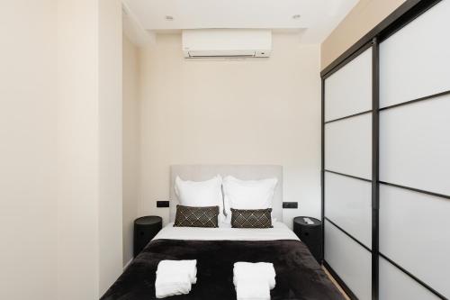 - une chambre avec un lit aux murs blancs dans l'établissement Palais Miramar YourHostHelper, à Cannes