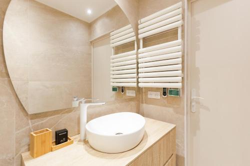 une salle de bain avec un lavabo blanc et un miroir dans l'établissement Palais Miramar YourHostHelper, à Cannes