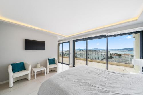 une chambre avec un grand lit et de grandes fenêtres dans l'établissement 5 Bedroom Cannes Penthouse - Ocean View, à Cannes