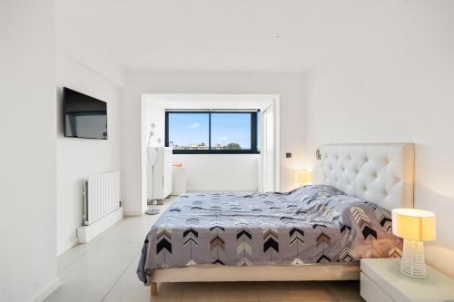 une chambre blanche avec un grand lit et une fenêtre dans l'établissement 5 Bedroom Cannes Penthouse - Ocean View, à Cannes
