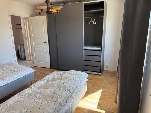 a bedroom with two beds and a walk in closet at Härligt boende i perfekt läge, v1 nyrenoverat in Borås