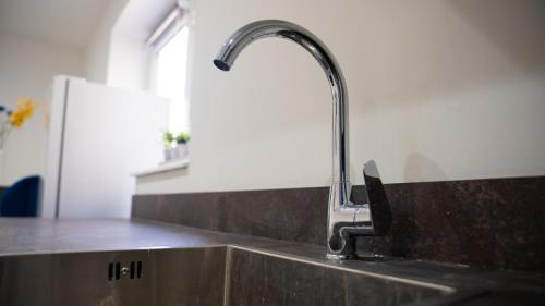a kitchen sink with a faucet on top of it at Luxury One Bedroom Flat - Cardiff City Centre in Cardiff