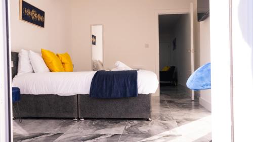 a bedroom with a large bed with yellow pillows at Luxury One Bedroom Flat - Cardiff City Centre in Cardiff