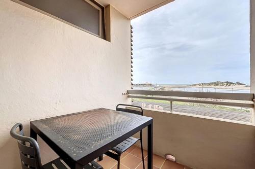 Una mesa y sillas en una habitación con ventana. en Le Neptune - Studio face à la plage - Parking, en Fleury