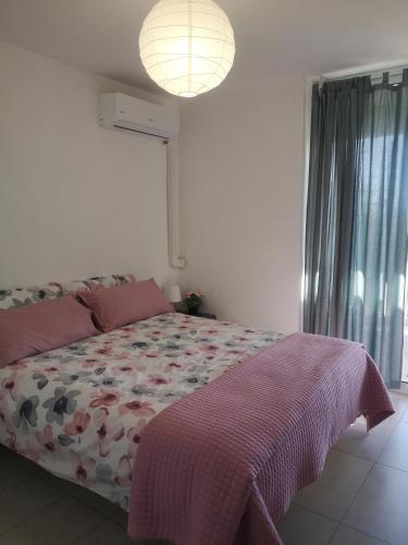 a bedroom with a bed with a comforter and a window at La terrazza sul mare in Letojanni