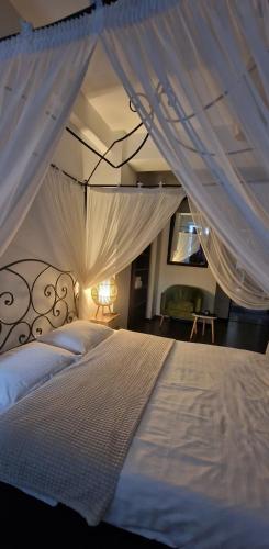 a bedroom with a white bed with a canopy at Hotel Jolie Apartments in Galaţi