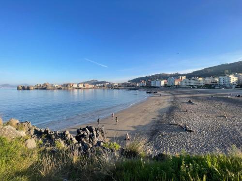a beach with people on the sand and the water at Verde & Mar in Castro-Urdiales