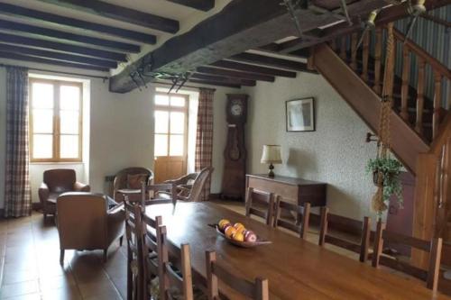 un salon avec une table et des chaises et un escalier dans l'établissement Le Saulnier-Longère berrichonne, à Chasseneuil