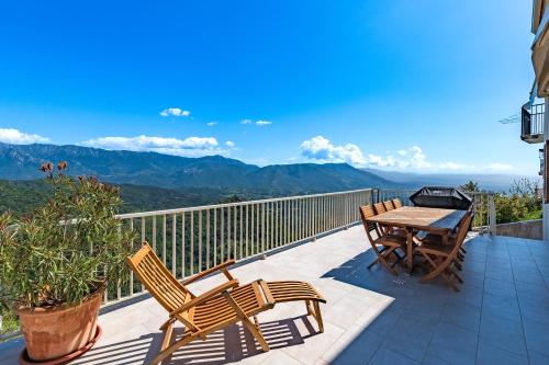 a patio with a table and chairs on a balcony at Casa Ultima - Superbe vue proche Ajaccio in Sarrola-Carcopino