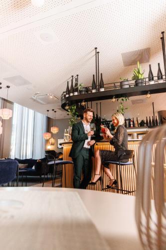a man and a woman sitting at a bar at Novotel Hamburg Central Station in Hamburg