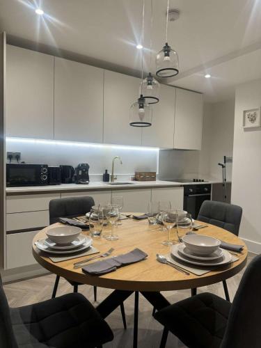 a wooden table in a kitchen with wine glasses at The Verulam Retreat in St. Albans