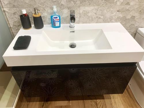 a white sink with two bottles on top of it at Mocha Luxury Residence in Spáta