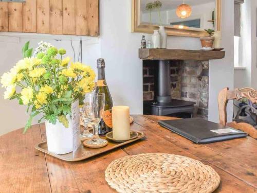 a table with a bottle of wine and flowers on it at The Pepper Pot Sleeps 4 Sunlit Garden in Exmouth