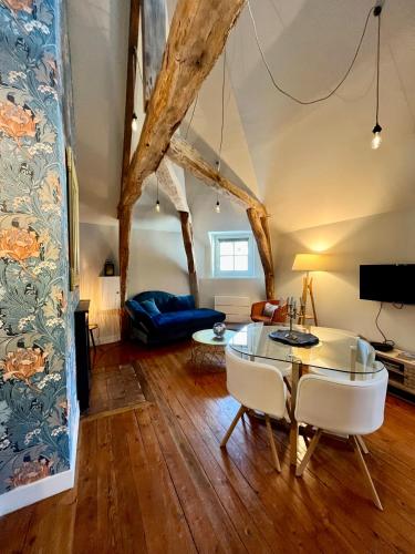 un salon avec une table en verre et des chaises dans l'établissement Le Gatsby - Duplex art déco au coeur de Blois, à Blois