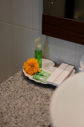 a bathroom counter with a sink with a flower on it at Desak Putu Putra Hidden in Ubud