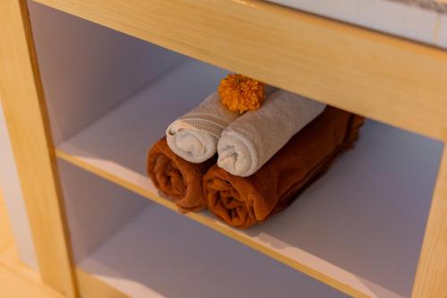 a pile of towels sitting on a shelf at Desak Putu Putra Hidden in Ubud