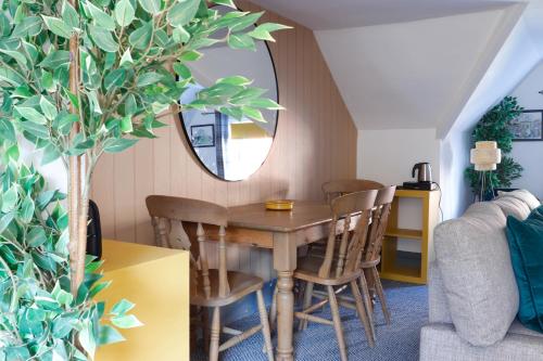 a dining room with a table and chairs and a mirror at Ashley Suite - Cozy 1BR Maisonette with Parking & WIFI in Barry