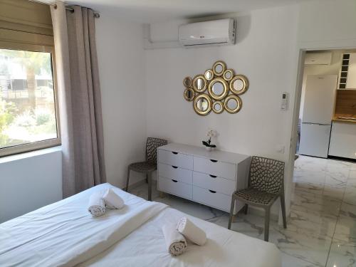 une chambre avec un lit, un bureau et des chaises dans l'établissement Residence Graziella Appartement 109, à Juan-les-Pins