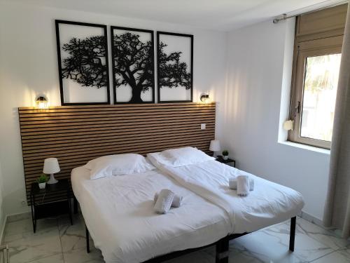 une chambre avec un lit blanc avec deux serviettes dessus dans l'établissement Residence Graziella Appartement 109, à Juan-les-Pins