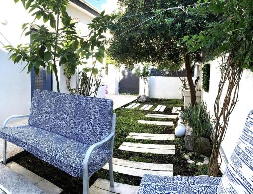 a blue bench sitting in the middle of a garden at 1922 Epoch Harmony Oikia in Volos