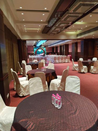 a conference room with tables and chairs and a stage at The President-A Boutique Hotel in Ahmedabad