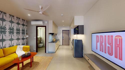 a living room with a yellow couch and a tv at Priya Hyderabad in Hyderabad