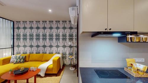 a living room with a yellow couch and a table at Priya Hyderabad in Hyderabad