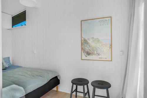 a bedroom with a bed and two stools at Lovely Holiday Home With Panoramic View Of The Fjord in Amtoft
